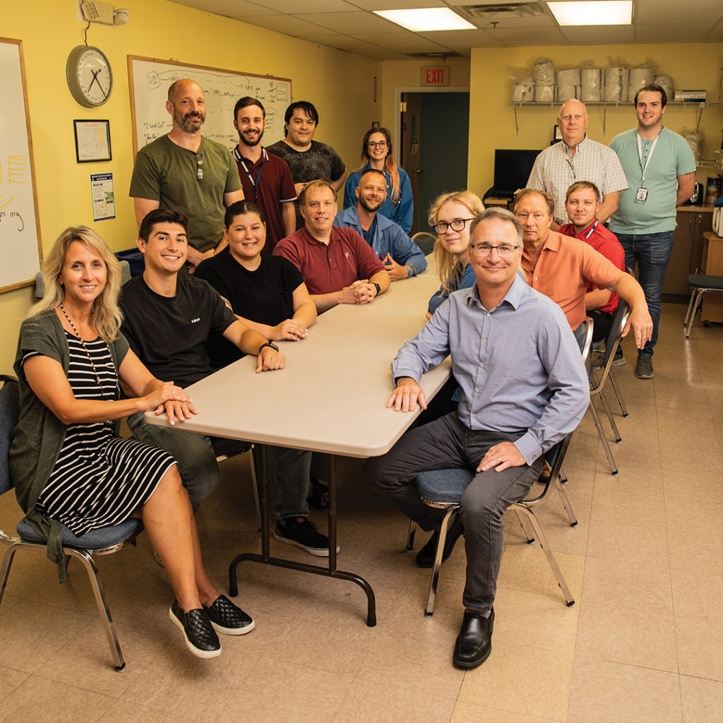 Roger Dorval (front right) and the many TCNJ alumni and students that work at Katz's Linearizer Technology.